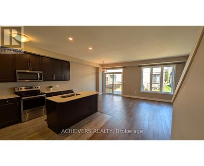 A spacious kitchen with dark wood cabinets and stainless steel appliances.