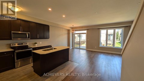 A spacious kitchen with dark wood cabinets and stainless steel appliances.