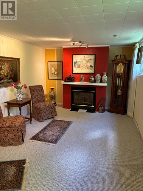 A living room with a fireplace and a painting on the wall.