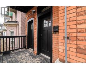 A black door is on the brick wall of a building.