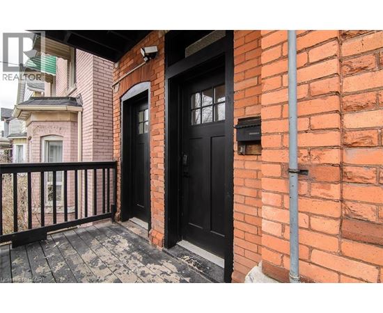 A black door is on the brick wall of a building.