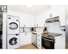 A white kitchen with a washer and dryer built in.