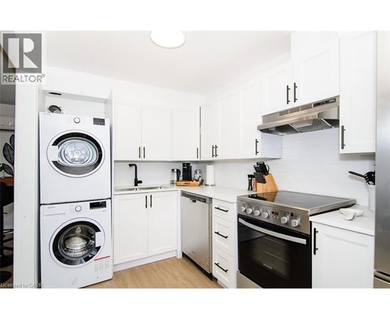 A white kitchen with a washer and dryer built in.