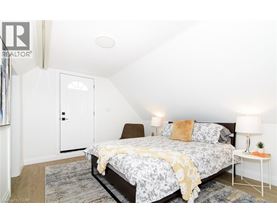 A bedroom with a bed, a nightstand, and a chair.