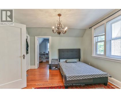 A bedroom with a large bed and a chandelier.