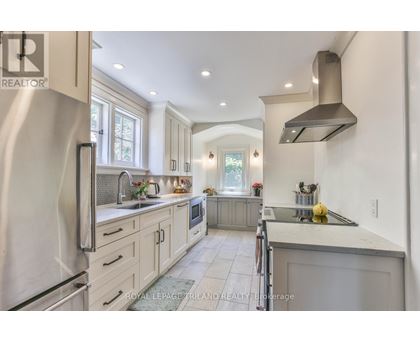A modern kitchen with a refrigerator on the left and a stove on the right.