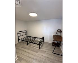 A bedroom with a bed and a chair.