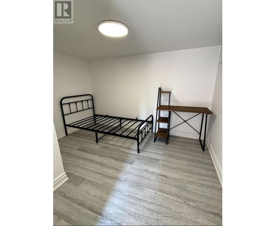 A bedroom with a bed and a wooden shelf.
