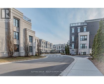 A street view of a residential area with buildings on both sides and a clear sky.