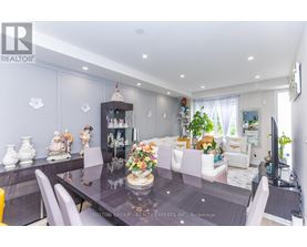 A dining room with a table set for six and a television on the wall.