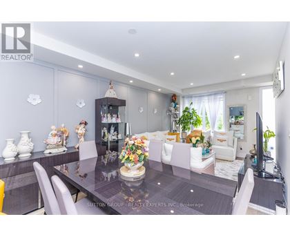 A dining room with a table set for six and a television on the wall.