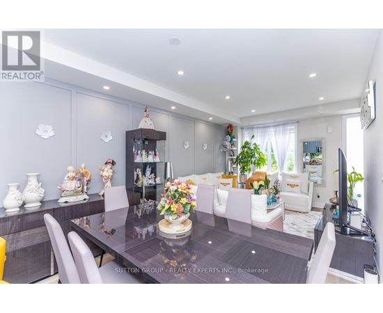 A dining room with a table set for six and a television on the wall.
