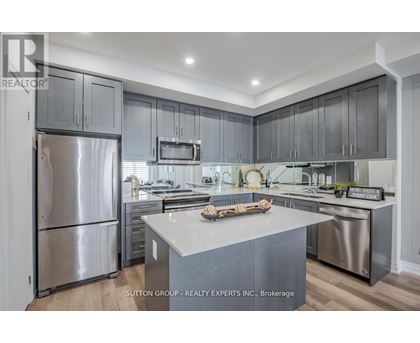 A modern kitchen with stainless steel appliances and a central island.