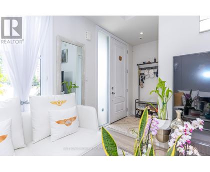A living room with a white couch and a large mirror on the wall.