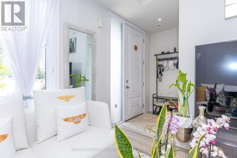 A living room with a white couch and a large mirror on the wall.