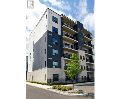 A modern apartment building with balconies and a tree in front.