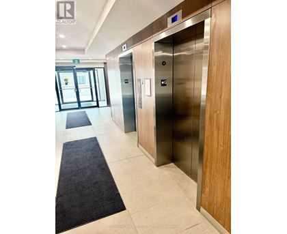 A hallway with two elevators and a door leading outside.
