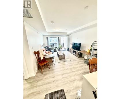 A living room with a couch, chairs, and a television.