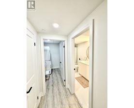 A hallway with a doorway leading to a bathroom.