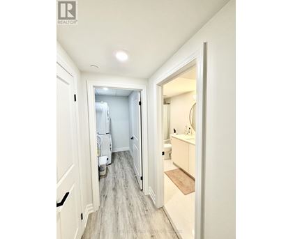A hallway with a doorway leading to a bathroom.
