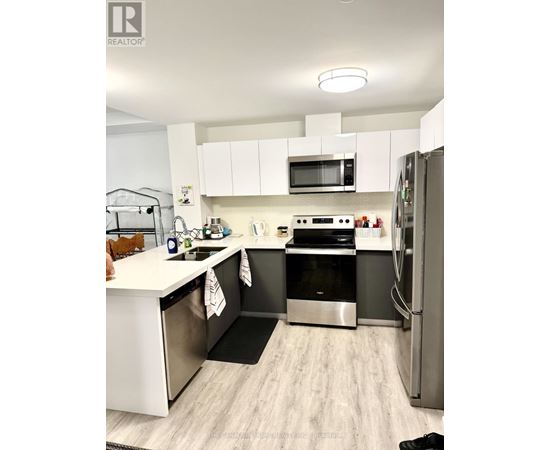 A modern kitchen with stainless steel appliances and white cabinets.