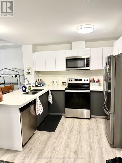 A modern kitchen with stainless steel appliances and white cabinets.