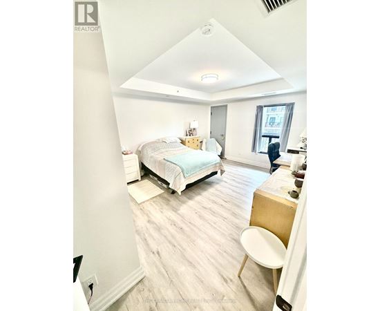 A bedroom with a bed, desk, and chair.