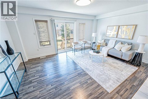 A living room with a white couch and a glass display case.