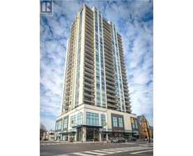 A tall building with many windows is the main focus of the image.