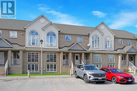A row of houses with two cars parked in front.