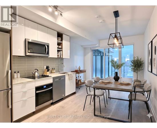 A modern kitchen with a dining table set for two.