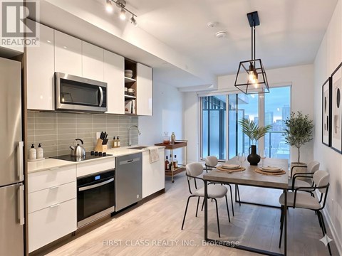 A modern kitchen with a dining table set for two.