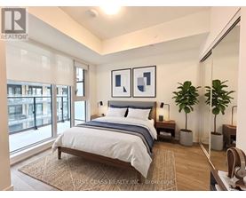A bedroom with a large bed and a window overlooking a city.