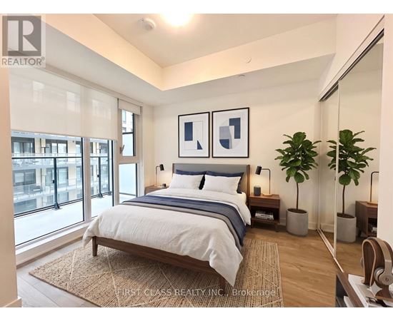 A bedroom with a large bed and a window overlooking a city.