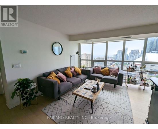 A living room with a grey couch and a coffee table in front of a large window.
