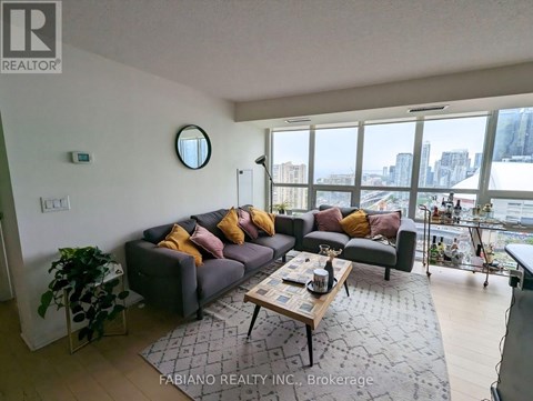 A living room with a grey couch and a coffee table in front of a large window.