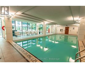 A large indoor swimming pool with a glass wall and a white ceiling.