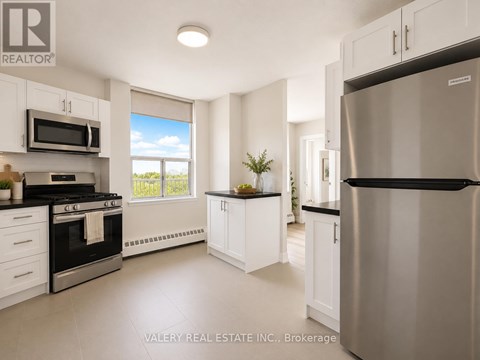 A modern kitchen with white cabinets and stainless steel appliances.