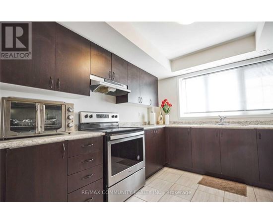 A kitchen with brown cabinets and a white stove top oven.