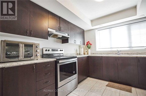 A kitchen with brown cabinets and a white stove top oven.