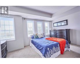 A bedroom with a bed, dresser, and window.