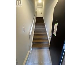 A staircase with a black wall and a white door.