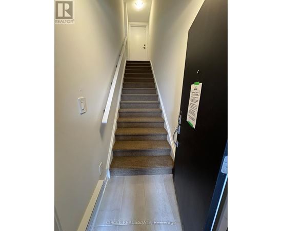 A staircase with a black wall and a white door.