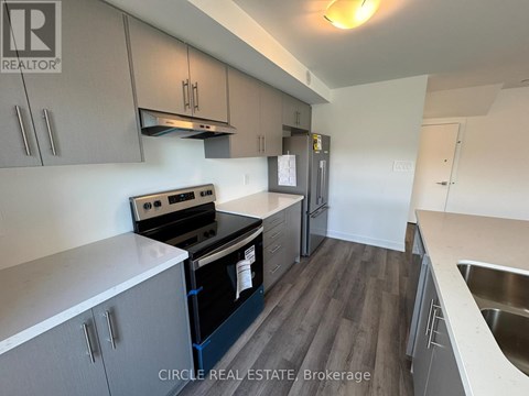 A kitchen with a stove top oven and a refrigerator.