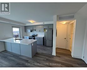 A kitchen with a refrigerator, stove, and cabinets.