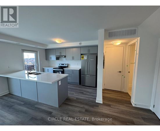 A kitchen with a refrigerator, stove, and cabinets.