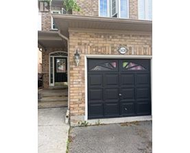 A black garage door with a white number 6630 on the brick wall above it.