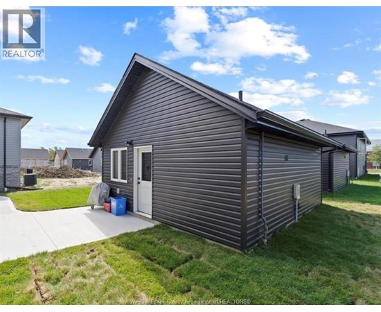 A small, single-story house with a grey exterior and a white door is for sale.