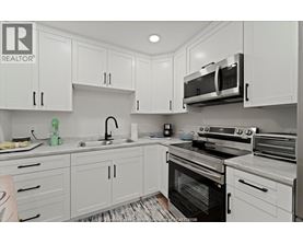 A kitchen with white cabinets and appliances.