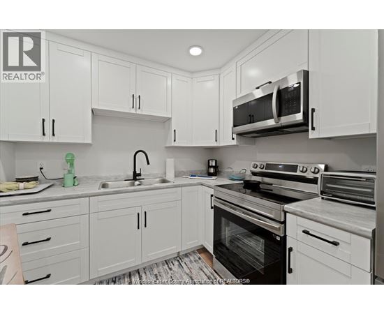 A kitchen with white cabinets and appliances.